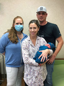 Matthew Tatum, right, and wife Sheila, center, embrace son Mason, William Newton Hospital’s New Year’s Baby delivered by Tarena Sisk, MSN, APRN, CNM-I, left.