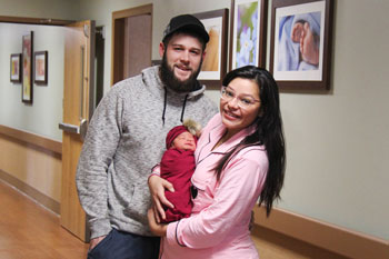 Gage Eastman, left, and Isabel Barron, right, embrace daughter Emma, William Newton Hospital’s New Year’s Baby.