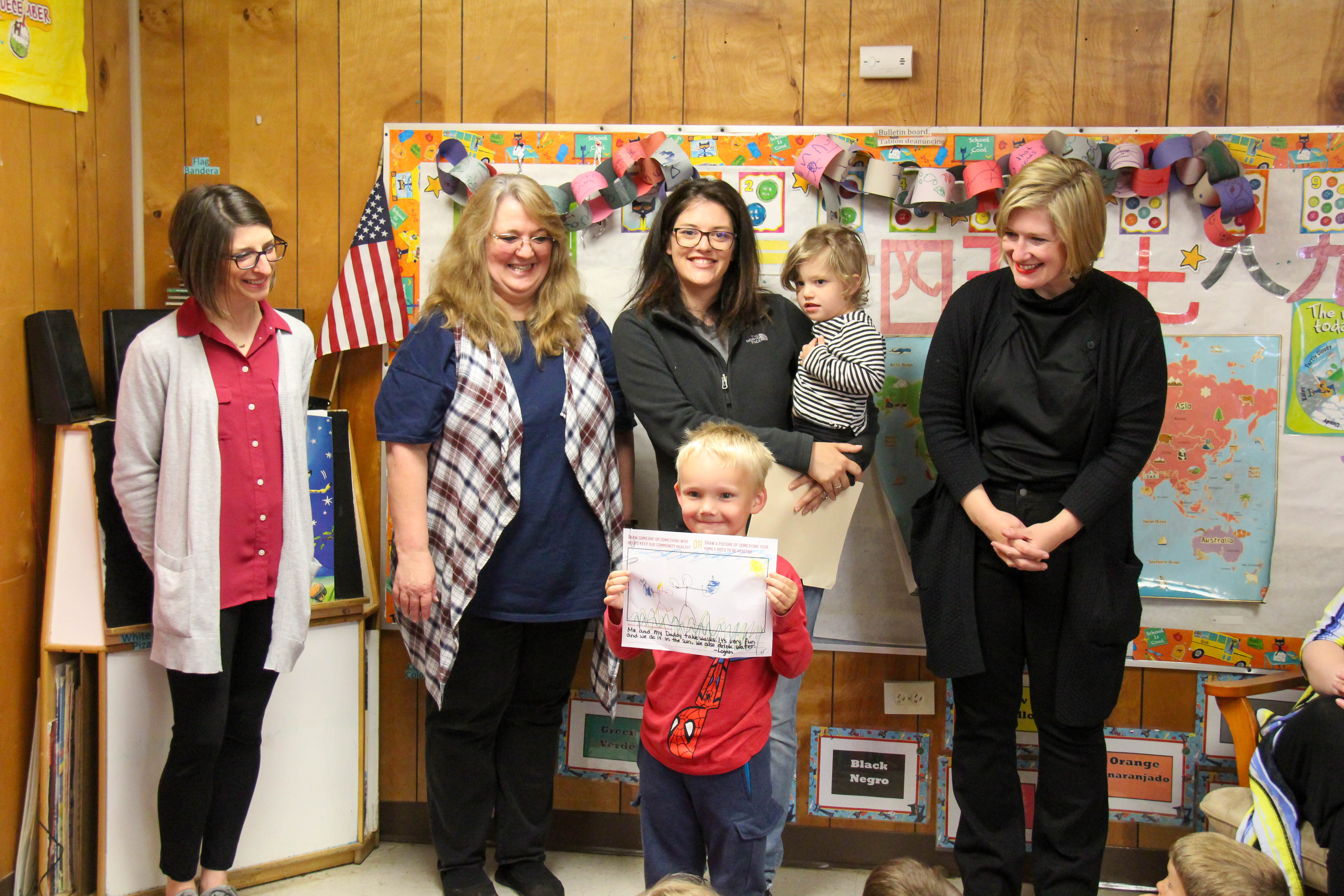 Logan Miers, front, proudly displays his winning design while representatives from Putting the heART Back into Healthcare are delighted to recognize him at the SC Learning Center. Back row from left: Ruth Bumgarner of William Newton Hospital Healthways, Cheri Gonzales of Winfield Arts and Humanities Council, Samantha Yeary (holding daughter Saylor Creed) of Winfield Arts and Humanities Council, and Annika Morris of William Newton Healthcare Foundation.