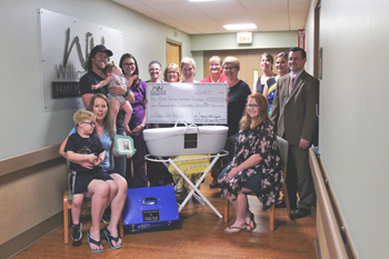 With many meeting for the first time, Cuddles for Noah project contributors gather in the Family Birthing Center to honor the successful acquisition of a CuddleCot at William Newton Hospital. From left: The Waggoners, Cole, Heather, Nathan, and Zoey; William Newton Hospital obstetrical nurses Erin Champlin, BSN, RN, CBE, and Farrah Gomez, RN; Choices Medical Clinic Nurse Manager Debbie Entz, BSN, RN, RGMS; William Newton Healthcare Foundation Director Annika Morris; William Newton Hospital Obstetrics Supervisor Debbie Marrs, RN; Choices Medical Clinic receptionist and volunteer Susan Wilson; Hunter Ferguson; Schmidt Jewelers co-owner Blanche Schmidt; and Shelley Family Funeral Home owners Lydia and Joseph Shelley.