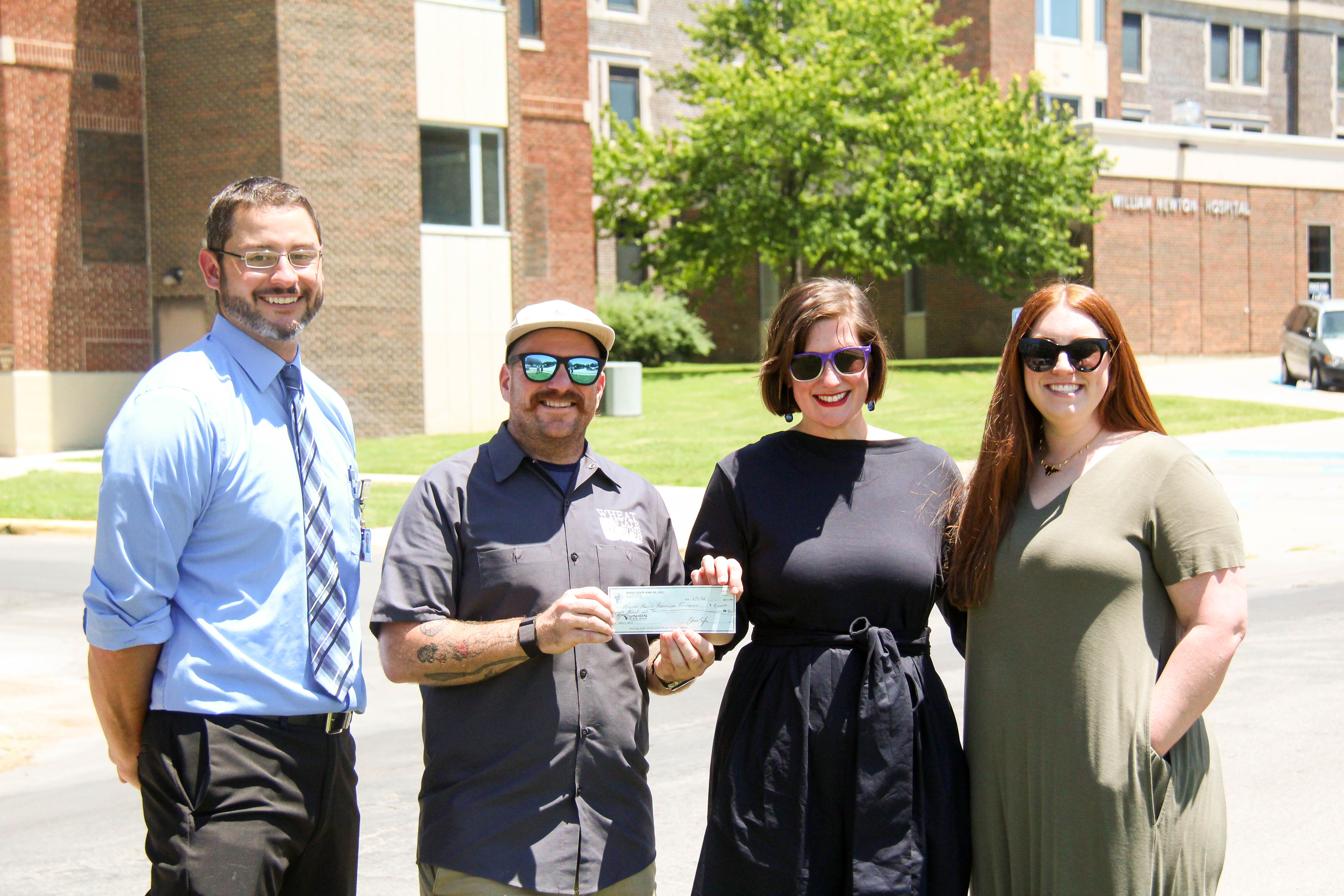 The William Newton Healthcare Foundation accepts a donation from Wheat State Wine Co. for a portion of the proceeds from the 10th Annual Wine-O Trail Run. From left: William Newton Hospital Interim CEO Brian Barta, Wheat State Wine Co. Owner/Winemaker Chris Tyler, William Newton Healthcare Foundation Executive Director Annika Morris, and Wheat State Wine Co. Director of Marketing and Events Lena Helms.