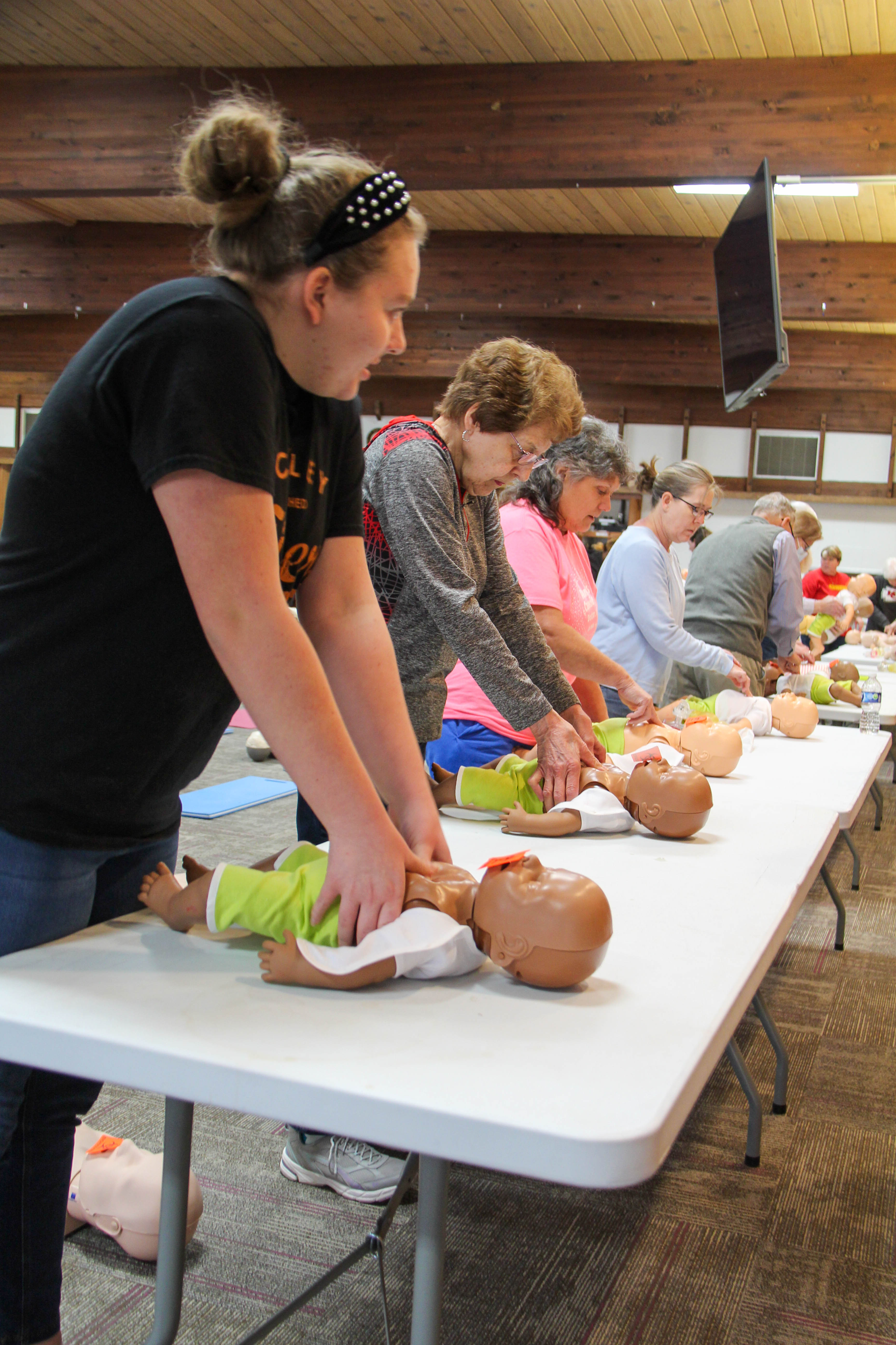 Participants line up to practice infant CPR at the community-wide training at Baden Square in Winfield.