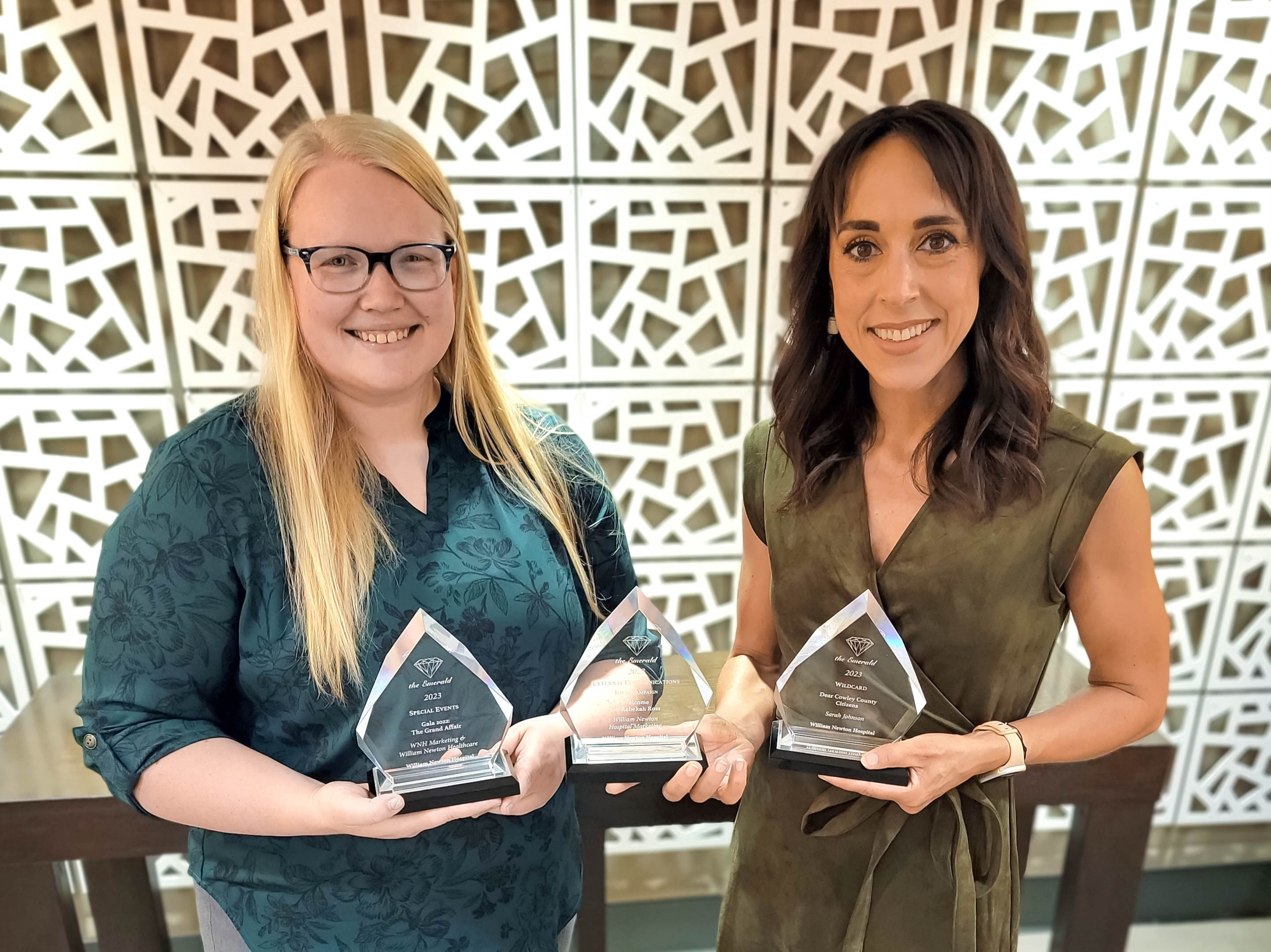 William Newton Hospital’s Kylie Stamper, left, and Sarah Johnson, right, display several awards earned for excellence in health care marketing and communications.
