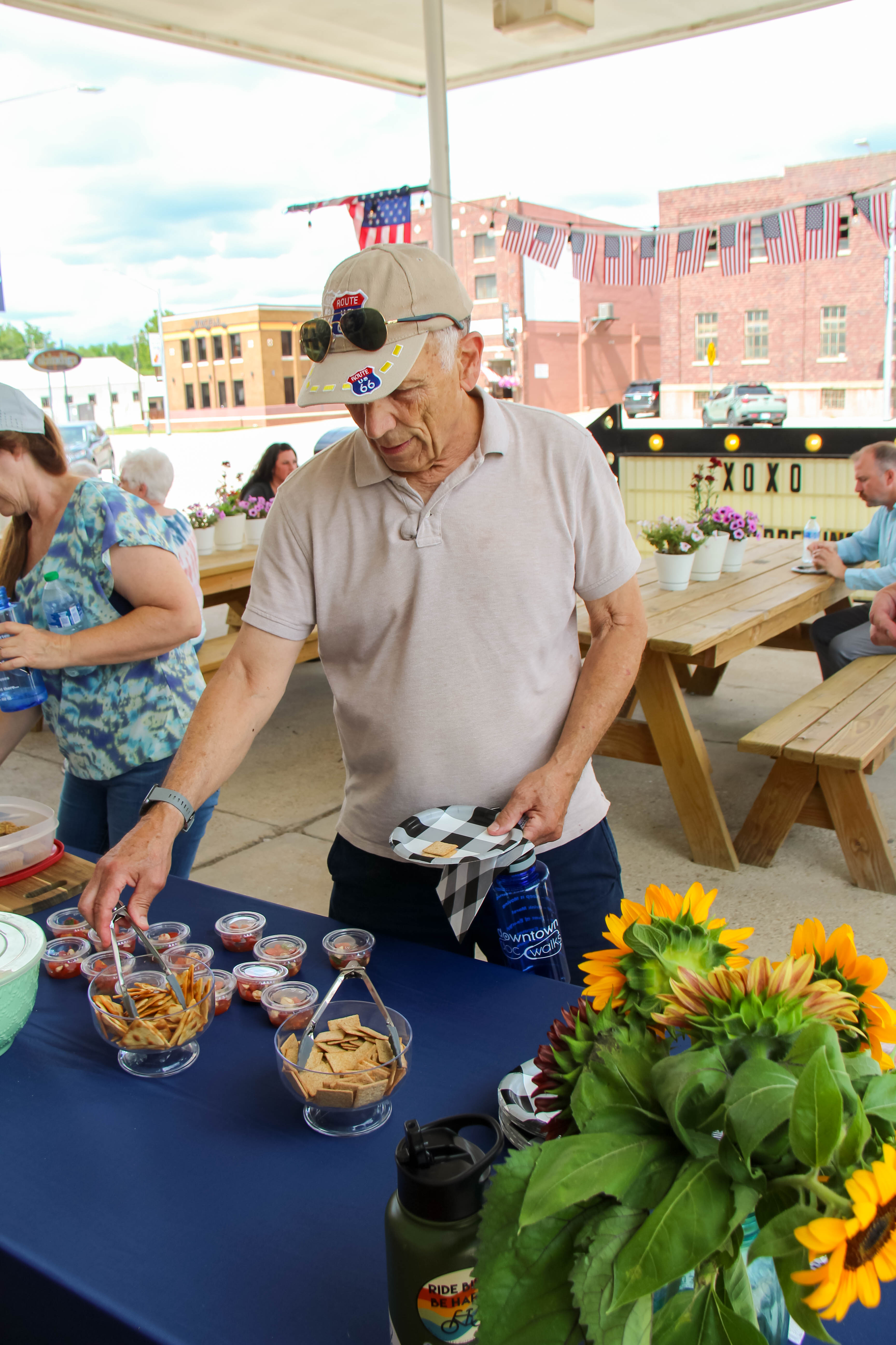 Downtown Doc Walk participant Gary Brewer samples Werner Creek Farm Store snacks made from fresh, local produce under the awning at Lady Bird Brewing.