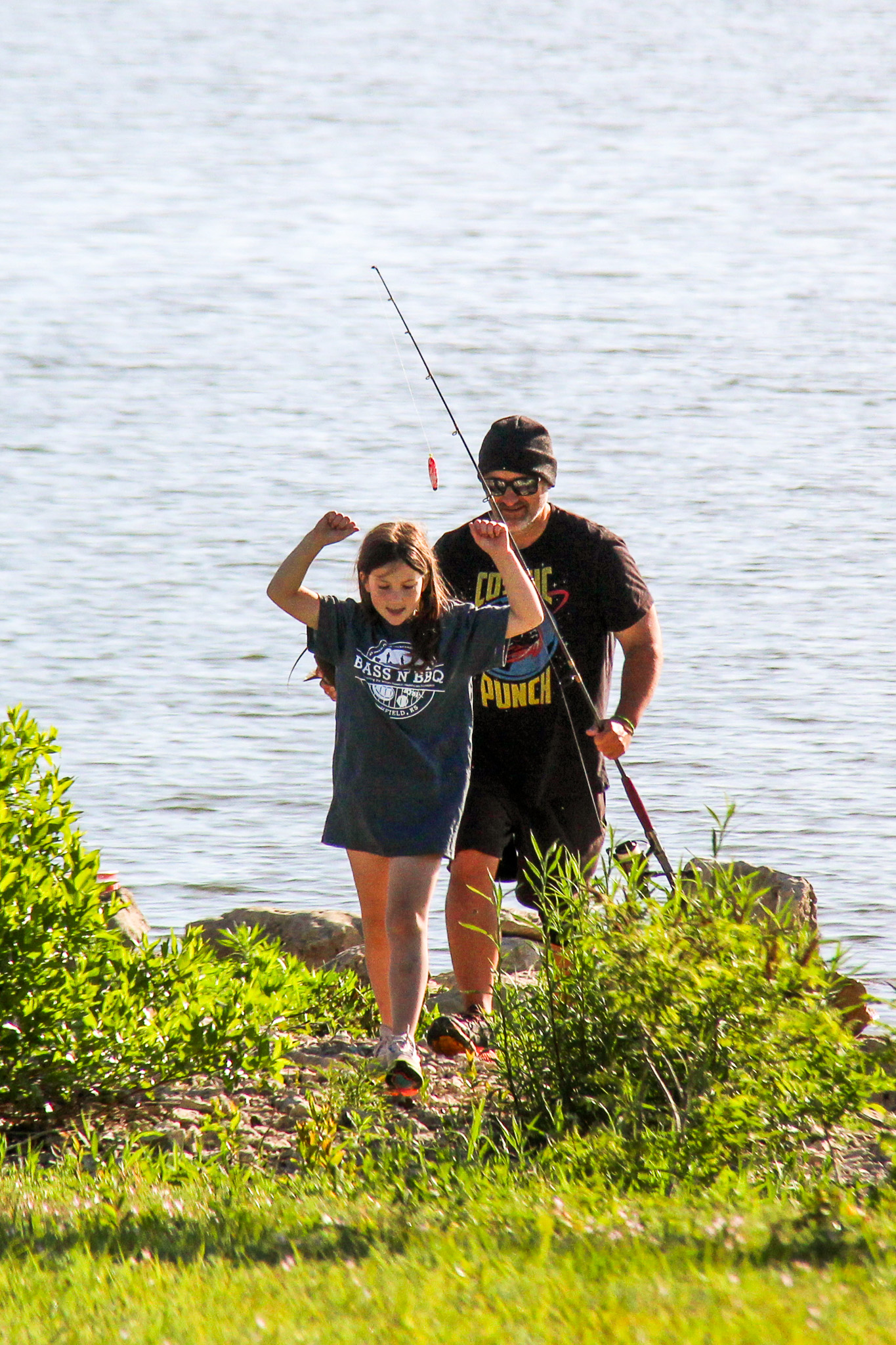 Charlotte Macklin, with her father John, celebrates her winning catch in the fishing derby, earning her cash prize and a new fishing pole.